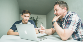 Picture of two men with a laptop studying a Health and Safety course.